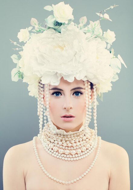 Femme élégante avec des fleurs blanches. Jeune visage, maquillage, roses et bijoux