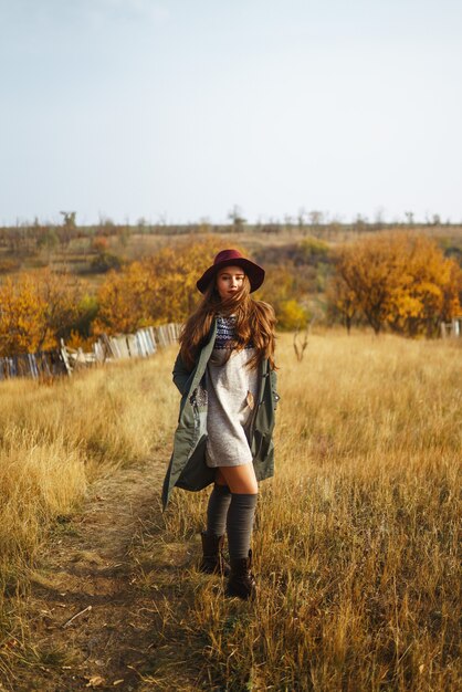 Femme élégante portant un manteau dans le parc de l'automne