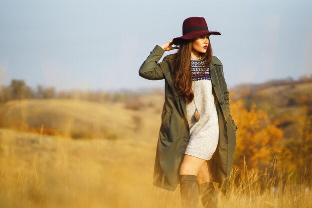 Photo femme élégante portant un manteau dans le parc de l'automne