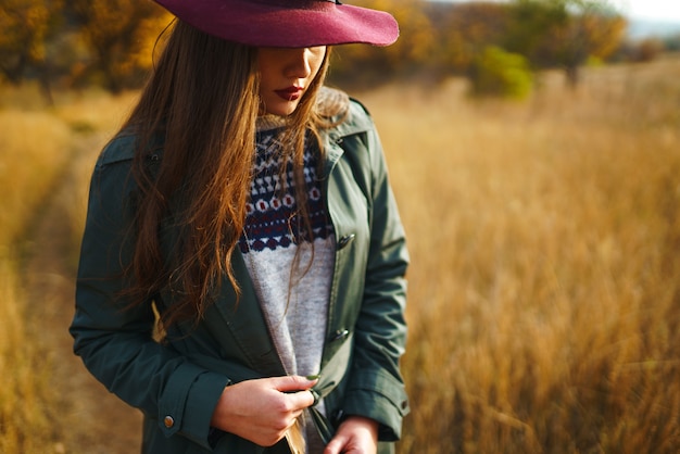 Femme élégante portant un manteau dans le parc de l'automne