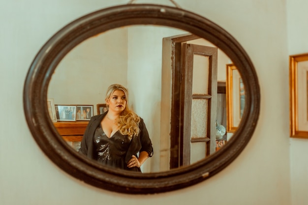 Femme élégante posant devant un miroir
