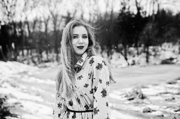 Femme élégante en robe à la journée d'hiver contre le lac gelé.