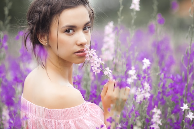 Femme élégante sexy sur la prairie de fleurs. Belle femelle à l'extérieur. Concept de liberté