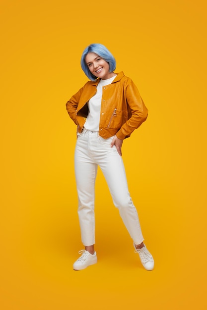 Femme élégante souriante aux cheveux bleus en studio