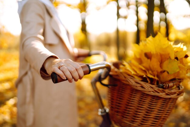 Une femme élégante avec un vélo appréciant le temps d'automne dans le parc Une belle femme dans la forêt d'hiver