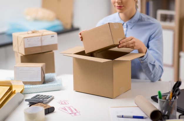 femme emballant une boîte à colis au bureau de poste