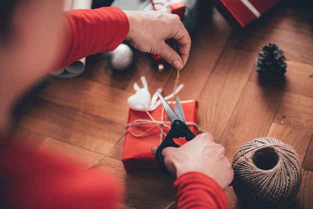 Femme emballant des cadeaux de Noël à la maison