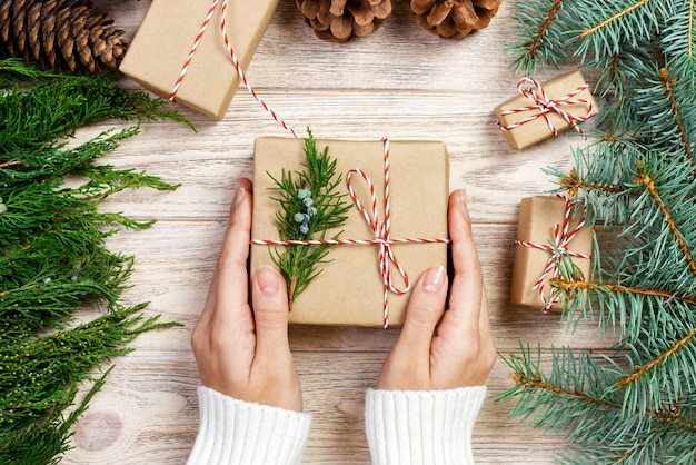 Femme emballant des cadeaux de Noël modernes à la maison