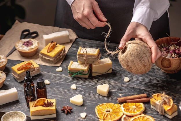 Une femme emballe un beau savon naturel décoré d'une tranche d'orange et d'un anis étoilé