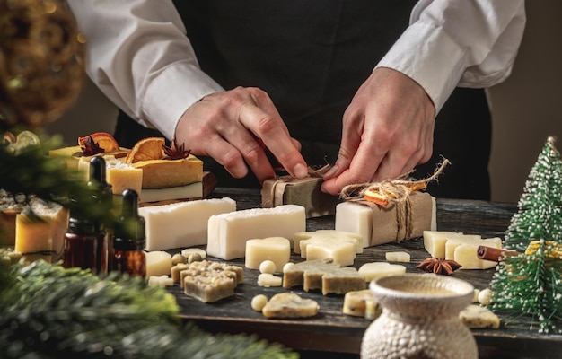 Une femme emballe du savon naturel fait main comme cadeau pour le Nouvel An et Noël Concept de préparation pour les loisirs de vacances une atmosphère festive et chaleureuse