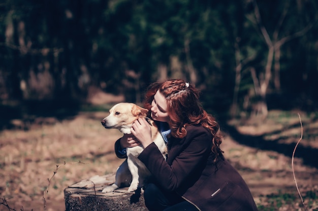 Femme Embrassant Un Chien En Forêt