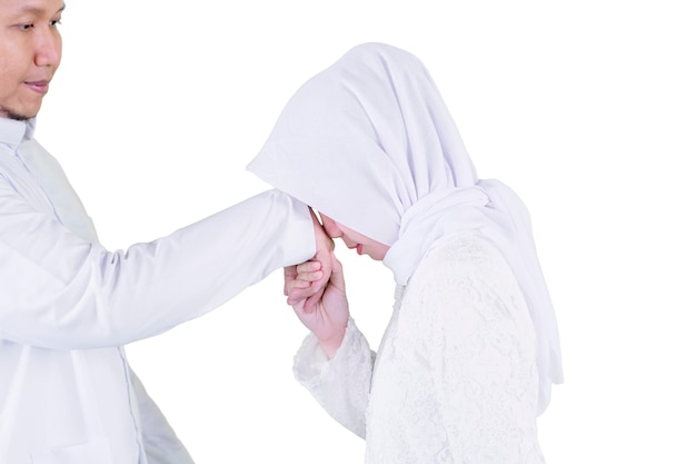 Femme embrassant les mains de son mari pendant l'Aïd Moubarak