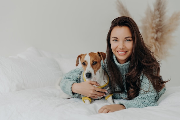 La femme embrasse le chien avec amour, passe du temps libre ensemble, exprime des sentiments et des émotions tendres