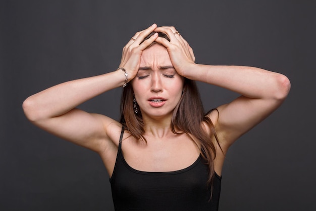 Femme émotionnelle désespérée, expressions faciales, fille stressée sur fond sombre