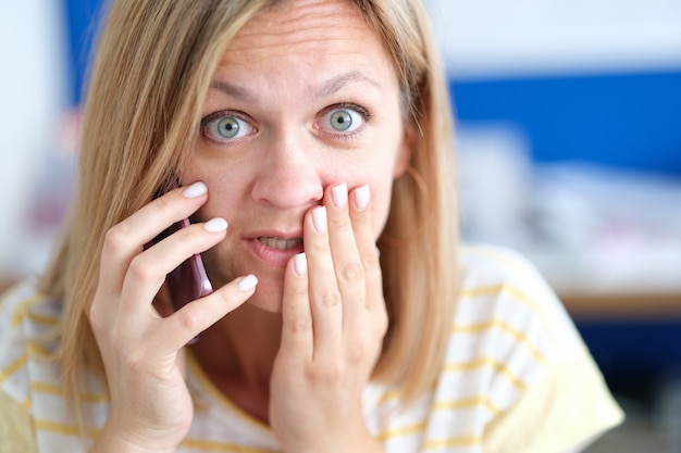 Photo femme émotionnellement confuse parlant au téléphone recevant de mauvaises nouvelles par téléphone concept