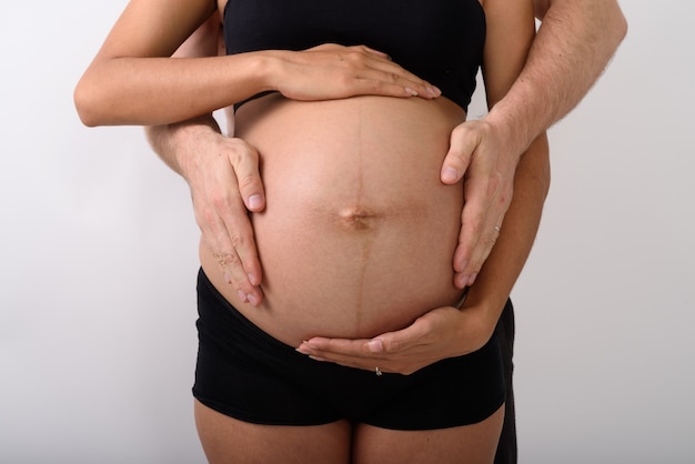 Femme enceinte asiatique avec homme tenant son ventre