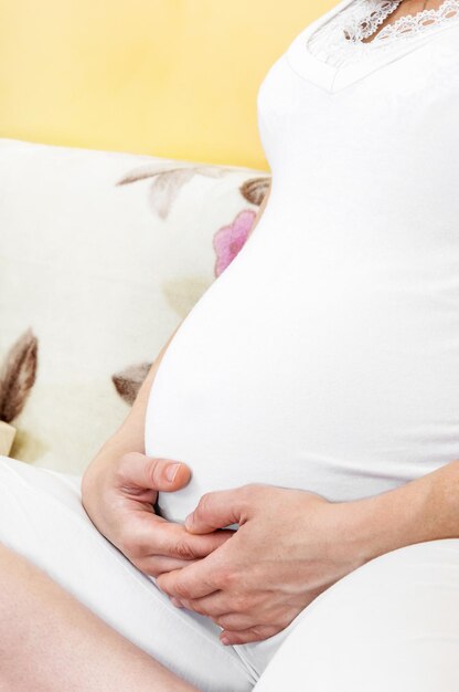 Femme enceinte assise sur le canapé