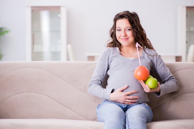 Femme enceinte assise sur un canapé