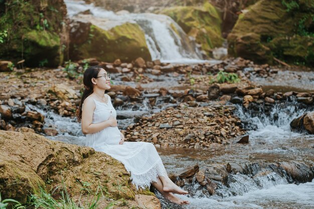 Femme enceinte assise à la cascade