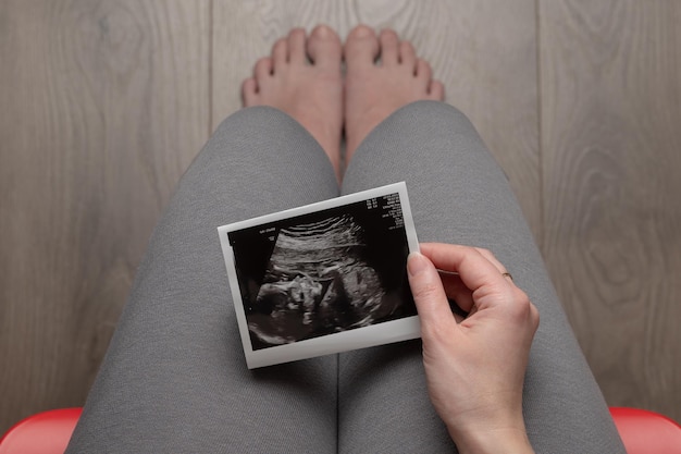 Une femme enceinte assise sur une chaise.