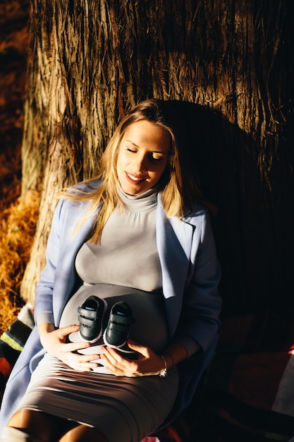 Femme enceinte assise sous l&#39;arbre d&#39;automne