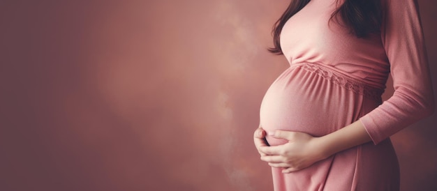 Femme enceinte au ventre rond portant un pull rose