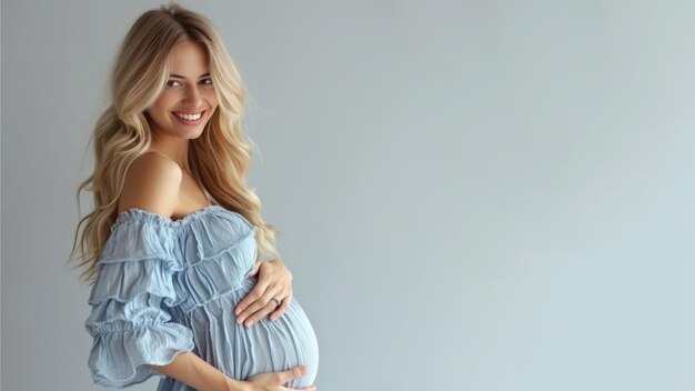 Une femme enceinte blonde avec un ventre de grossesse dans des vêtements bleus doux
