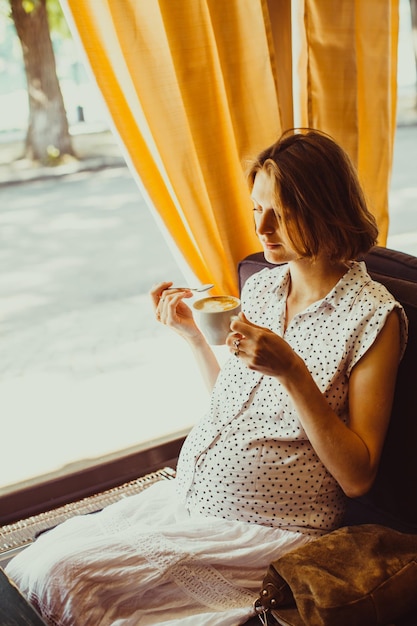 La femme enceinte boit du café au lait