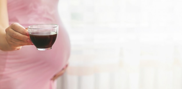 Une femme enceinte boit du café