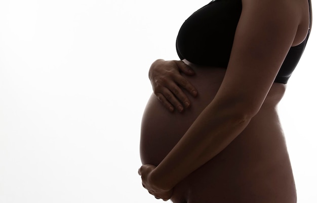 Femme enceinte avec une bosse de bébé se découpant sur un fond blanc