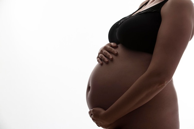 Femme enceinte avec une bosse de bébé se découpant sur un fond blanc