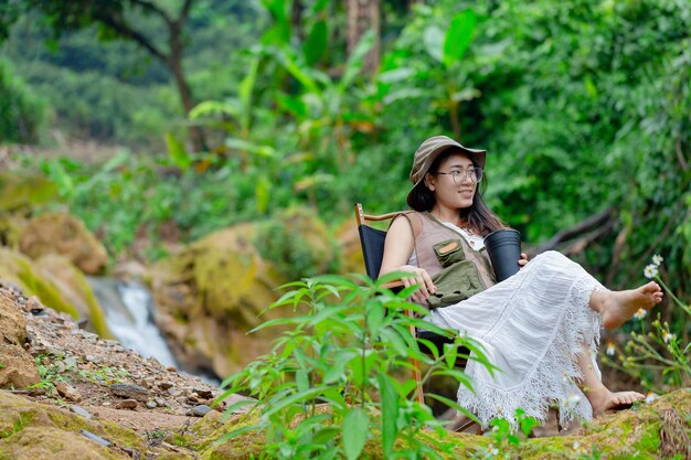 Femme enceinte buvant de l'eau près de la cascade