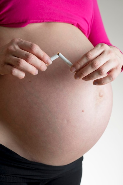 Femme enceinte casser une cigarette en deux