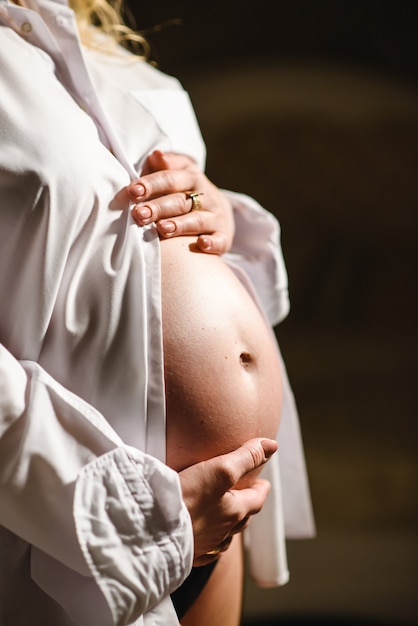 Femme enceinte en chemise blanche