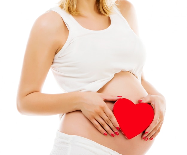 Femme enceinte avec coeur rouge