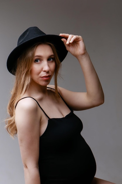 Photo une femme enceinte en costume noir et un espace chapeau noir pour copier le concept de digestion saine ...