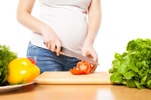 La Femme Enceinte Coupe La Tomate à Bord En Gros Plan