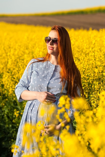 Femme enceinte dans le champ jaune