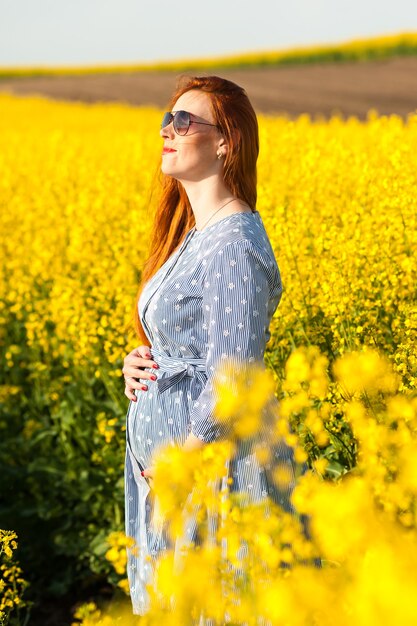 Femme enceinte dans le champ jaune