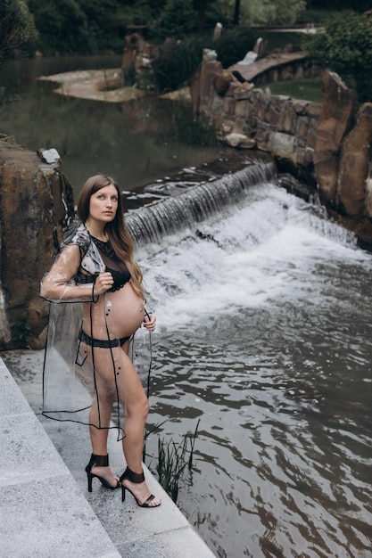 femme enceinte dans un imperméable dans le parc