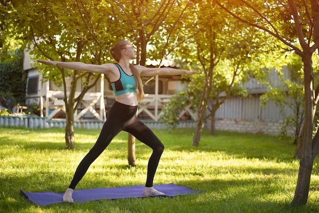 Femme enceinte dans le jardin pratique le yoga