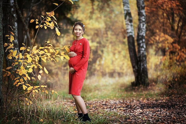 Femme enceinte dans le parc d'automne