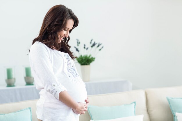 Femme enceinte dans le salon à la maison