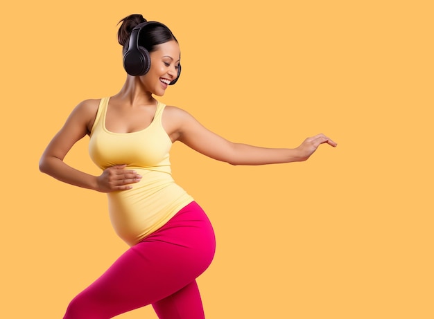 Une femme enceinte dansant et faisant de l'exercice en vêtements de sport avec un fond ocre ordinaire