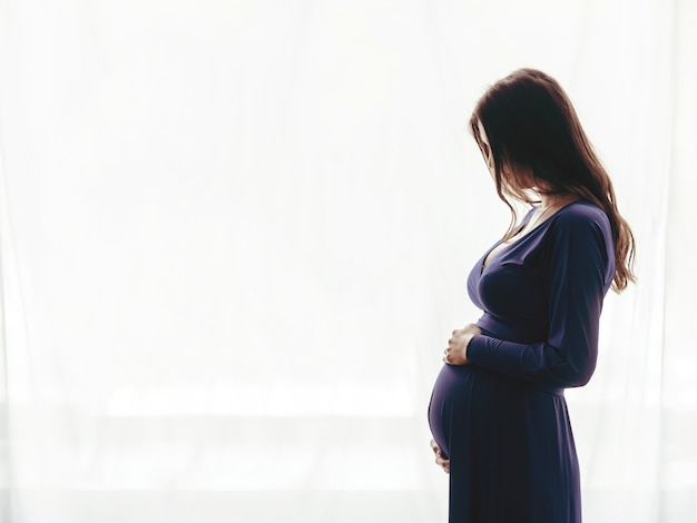 Femme Enceinte Debout Contre La Fenêtre