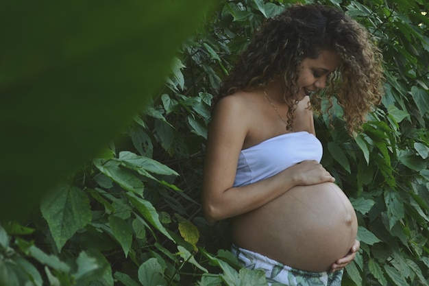 Photo femme enceinte debout près des plantes