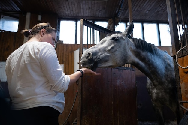 Une femme enceinte donne une pomme à son cheval