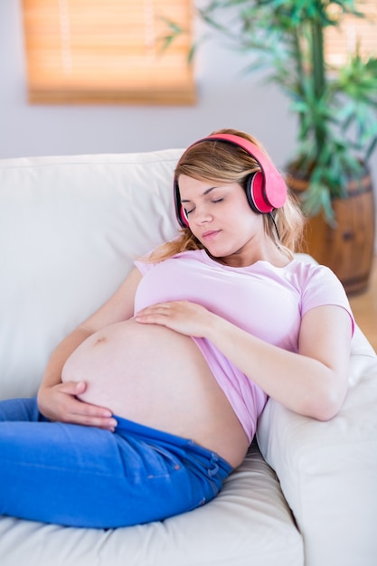 Femme enceinte écoute de la musique et de toucher son ventre