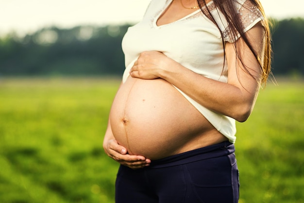 Femme enceinte embrasse son ventre