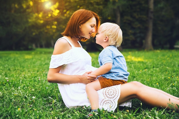 Femme enceinte avec enfant en bas âge à l'extérieur Mère et son fils sur la nature dans le parc d'été